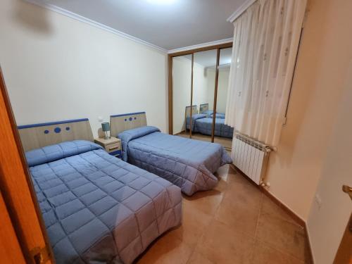 a bedroom with two beds and a window at Apartamentos Rapadoira in Foz
