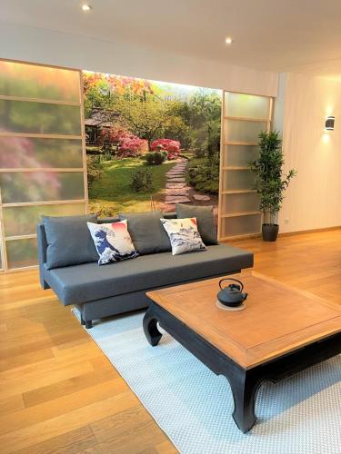 a living room with a couch and a coffee table at Le KYOTO Deco ZenCenterFIBREparking in Chalon-sur-Saône