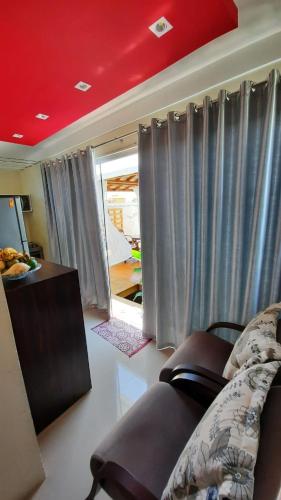 a living room with a couch and gray curtains at Bangalô in Porto Seguro