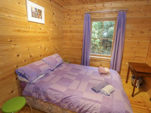 1 dormitorio con 1 cama en una cabaña de madera en Ardcuillean, en Cornamucklagh South