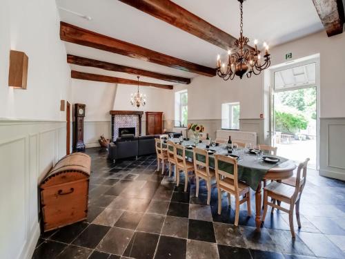 a dining room with a long table and chairs at Castle in Ferri res with a garden terrace and pond in Ferrières