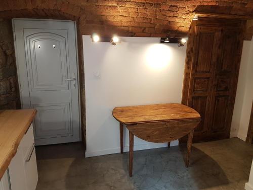 uma cozinha com uma mesa de madeira e uma parede branca em Gite A campinca em Calcatoggio