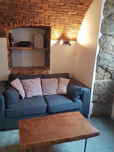 uma sala de estar com um sofá azul e uma mesa em Gite A campinca em Calcatoggio