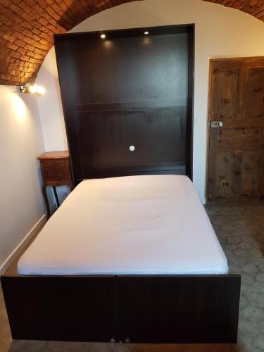 a bed in a room with a black bed frame at Gite A campinca in Calcatoggio
