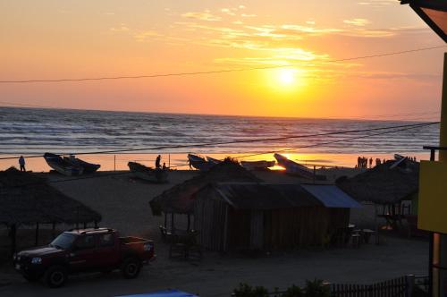 a truck parked on the beach at sunset at Hotel Canoa´s Wonderland in Canoa