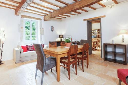 Il dispose d'une cuisine et d'un salon avec une table et des chaises en bois. dans l'établissement Villa charmante à Dunes avec piscine privée, à Dunes