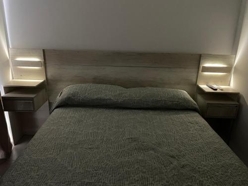 ein Schlafzimmer mit einem Bett mit zwei Nachttischen und zwei Tischen in der Unterkunft Departamento Parque in Paraná