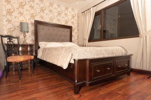 a bedroom with a bed and a chair and a window at Hotel Azul de la Plaza by Chat Noir in Cuenca