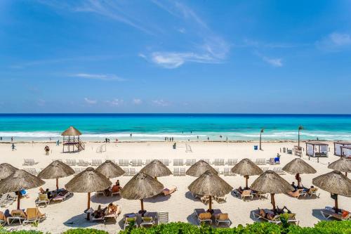 una playa con sombrillas y gente en la playa en Condos in Prime Cancun Location Plus 3 Pools, en Cancún