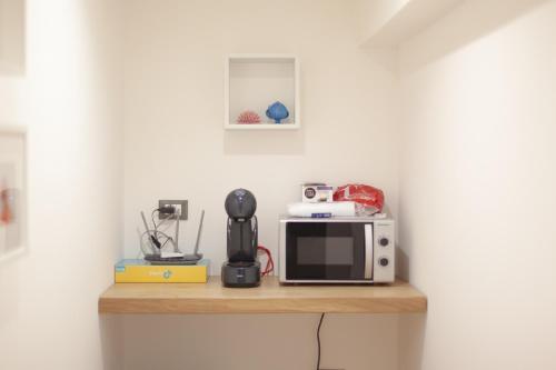 a counter with a microwave and a blender on it at AC Home in Novoli