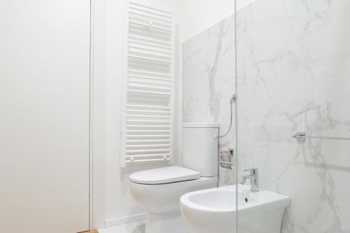 a white bathroom with a toilet and a sink at AC Home in Novoli