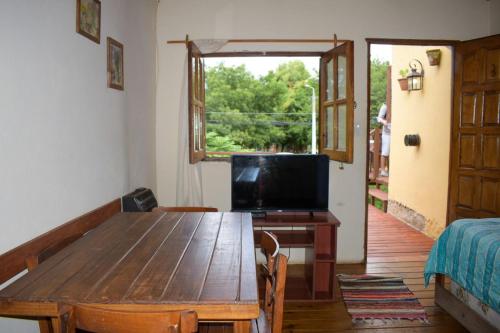 sala de estar con mesa de madera y TV en Complejo Los Molles en Potrero de los Funes