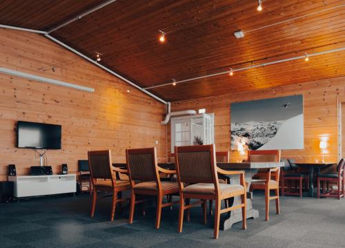 Habitación con mesa, sillas y TV de pantalla plana. en Austbø Hotell, en Rauland