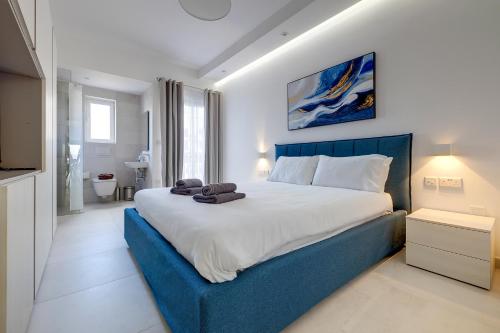 スリーマにあるDeluxe Apartment with Valletta and Harbour Viewsのベッドルーム1室(大型ベッド1台、青いヘッドボード付)