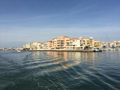 un groupe de bâtiments sur une masse d'eau dans l'établissement Studio 31 Le Cap d'Agde vue mer, proche plage, l'île des pêcheurs, au Cap d'Agde