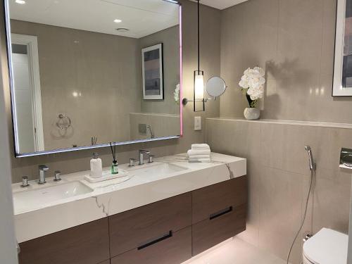 a bathroom with a sink and a large mirror at Luxurious apartment at address residences in Fujairah