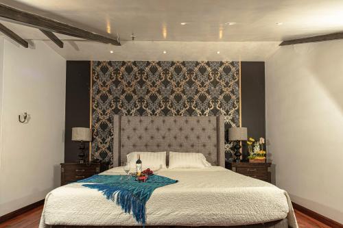 a bedroom with a large bed and a wall at Hotel Azul de la Plaza in Cuenca