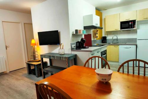une cuisine et une salle à manger avec une table en bois et une salle à manger gmaxwell gmaxwell dans l'établissement Maison confortable à Hourtin 45 m² avec piscine partagée sur place !, à Hourtin