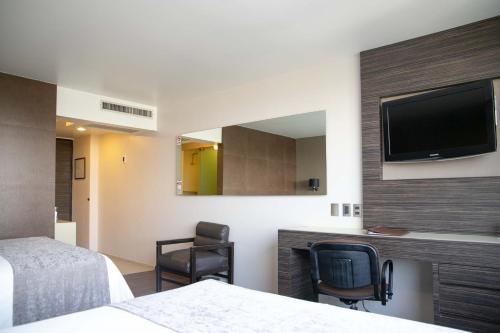pokój hotelowy z dwoma łóżkami i telewizorem z płaskim ekranem w obiekcie Hotel Brasilia w mieście Meksyk
