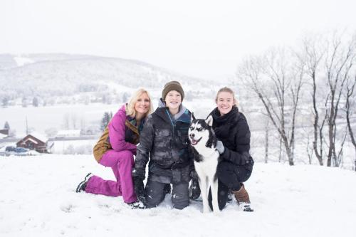 three women and a dog posing in the snow at The Lodges at Sunset Village in McHenry