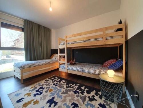 a bedroom with two bunk beds and a rug at Apartamento Posets in Jaca