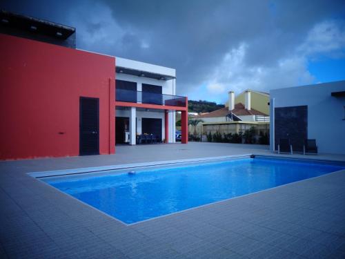 a swimming pool in front of a house at Mar & Serra in Feteiras