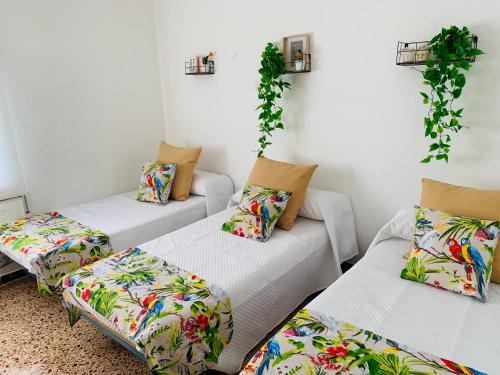 a living room with three couches and plants at La casa de l'Estany in L'Ametlla de Mar