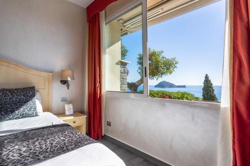 1 dormitorio con ventana y vistas al océano en Baba Residences en Alassio