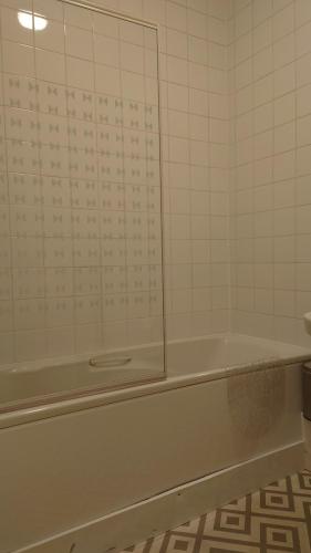 a bathroom with a bath tub with a mirror at Corner Hotel in Carnoustie