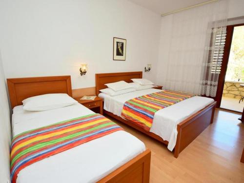 a hotel room with two beds and a window at Holiday Apartement Marija Supetar with private pool in Supetar