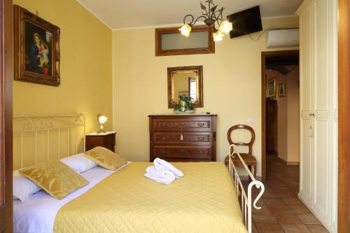 sypialnia z łóżkiem, komodą i lustrem w obiekcie Casa Antico Borgo Cuseni w Taominie