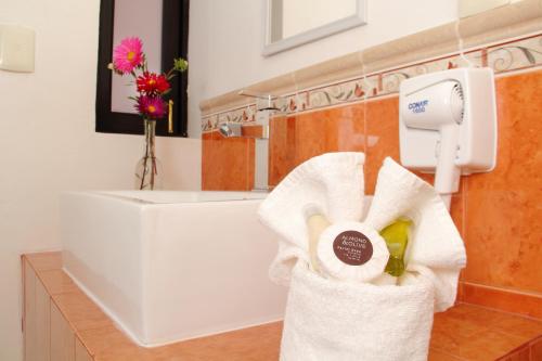 a bathroom with a towel dispenser and a sink at Hotel La Casa de María in Oaxaca City
