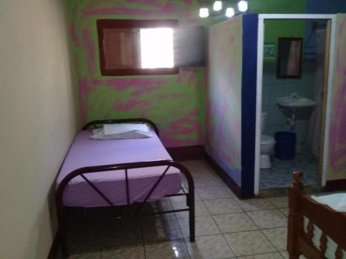 a small room with a bed and a sink at Hostal Maria in Rivas