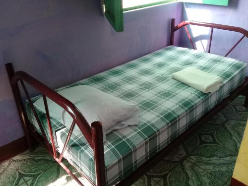 a small bunk bed with a green and white mattress at Hostal Maria in Rivas