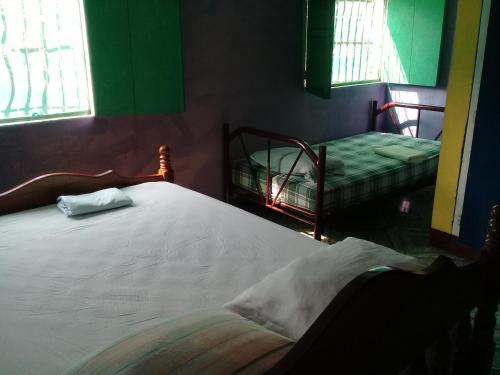 a bedroom with a bed and two bunk beds at Hostal Maria in Rivas
