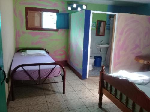 a small room with a bed and a bathroom at Hostal Maria in Rivas