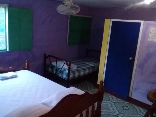 a purple room with two beds and a doorway at Hostal Maria in Rivas