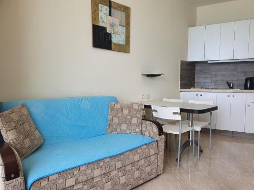 a living room with a blue couch and a table at Sea View Deluxe in Bat Yam