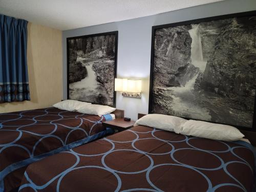 a hotel room with two beds and a painting on the wall at Super 8 North Red Deer in Red Deer