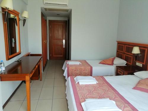 a hotel room with three beds and a desk at Grand Nar Hotel Adults Only in Kemer