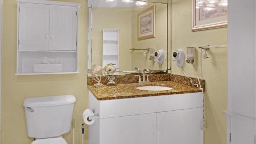 a bathroom with a toilet and a sink at South Beach Condo Hotel in St. Pete Beach