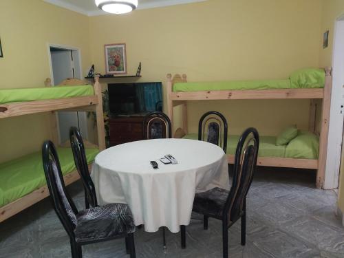 a room with a table and four bunk beds at Chapadmalal Casas La Bella in Colonia Chapadmalal