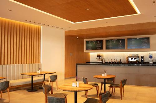 a restaurant with tables and chairs and a counter at Secrets Bahia Mita Surf and Spa - All Inclusive - Adults Only in Punta Mita