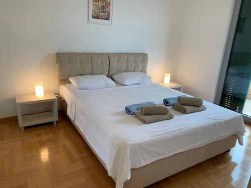 een slaapkamer met een groot wit bed met 2 kussens erop bij Lavender Bay Apartment B23 in Kotor