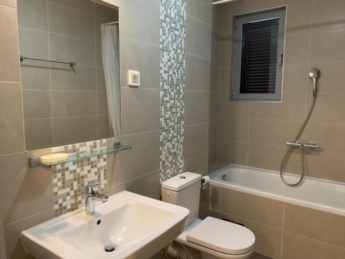 een badkamer met een wastafel, een toilet en een bad bij Lavender Bay Apartment B23 in Kotor