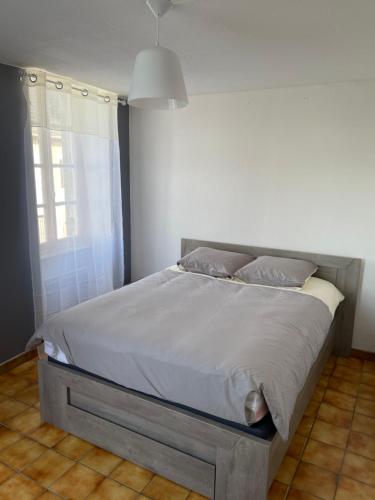 Ce lit se trouve dans une chambre dotée d'un mur blanc. dans l'établissement Charmant T2 au 1er dans résidence avec parc arboré, à Saint-Pierre-le-Moûtier