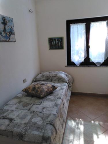 a bedroom with a couch and a window at Villa panoramica immersa nel verde in Porto Pino