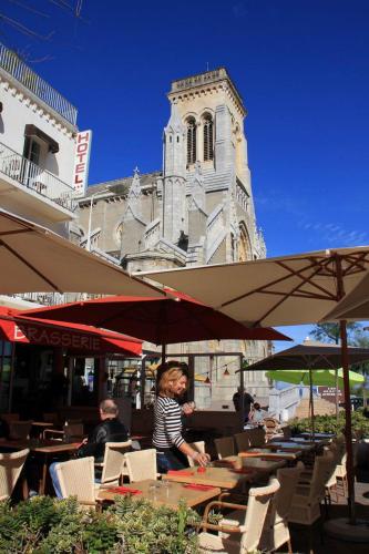 a woman sitting at a table in front of a building at Hotel De L'Océan in Biarritz