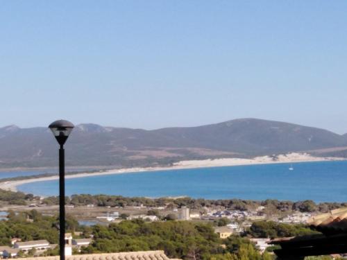 a view of a city and the ocean with a street light at Villa panoramica immersa nel verde in Porto Pino