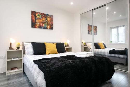 Un dormitorio con una cama grande y un espejo. en Nottingham Top Serviced Home - Chayil Experts, en Nottingham
